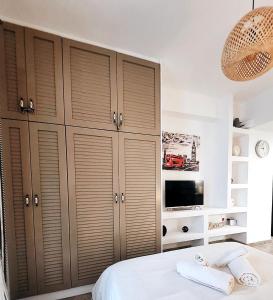Schlafzimmer mit Holzschränken und TV in der Unterkunft X P apartment koukaki perfect place to stay in Athen