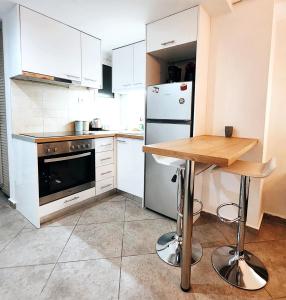 eine Küche mit einem Holztisch und einem Kühlschrank in der Unterkunft X P apartment koukaki perfect place to stay in Athen