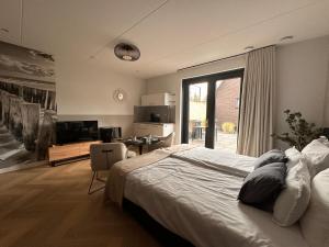 um quarto com uma cama, uma secretária e uma cozinha em De Zilten Kaēmer Zoutelande em Zoutelande