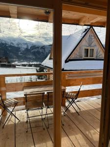 a view from the porch of a cabin with a table and chairs at Domki Widokowe -Przystanek Salamandra in Kościelisko