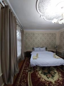 a bedroom with two beds and a large window at Fayz Guest House in Samarkand