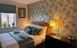 a bedroom with a bed and a desk with a lamp at Clocktower Suite in Exeter