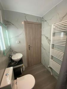 een badkamer met een toilet, een wastafel en een deur bij Alexandra apartment in Athene