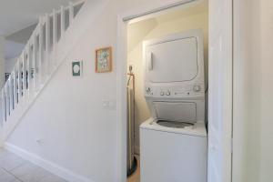 eine Waschmaschine und einen Trockner in einem Zimmer mit einer Treppe in der Unterkunft LAKE PALMS 1 in Sanibel