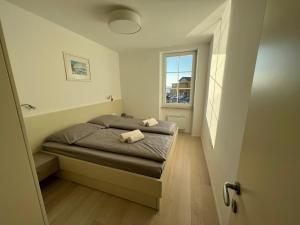 a small bedroom with a bed and a window at Gloria Holiday - Apartment Rebecca in Piran