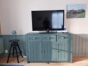un armario azul con TV encima en Per-Sims, en Ljusdal