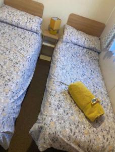 a bedroom with a bed with a yellow pillow on it at LottieLou’s Hot Tub breaks at Tattershall Lakes in Lincoln