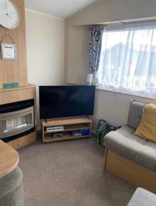 a living room with a flat screen tv and a couch at LottieLou’s Hot Tub breaks at Tattershall Lakes in Lincoln
