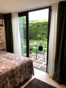 a bedroom with a bed and a sliding glass door at Prachtig guesthouse aan het water in Almere