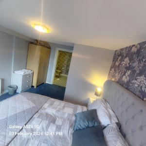 1 dormitorio con 1 cama y 1 sofá en Mews Apartment Main St, Carrigart, F92HC04 en Carrigart