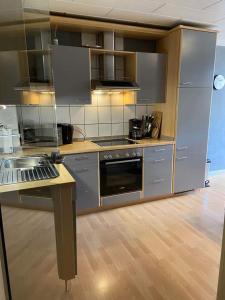 a kitchen with stainless steel appliances and wooden floors at Ferienhaus Elisa in Trittenheim
