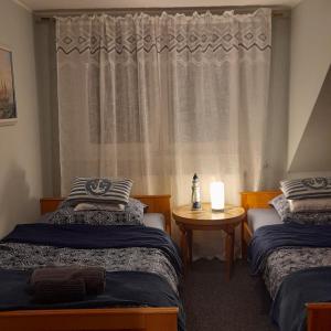 a bedroom with two beds and a window at Grzybki Trzy in Iława