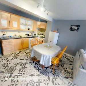 a kitchen with a table with chairs and a refrigerator at Mews Apartment Main St, Carrigart, F92HC04 in Carrigart