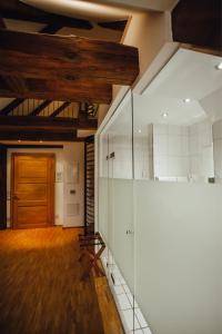 Habitación con puerta de madera y pared de cristal. en Hotel "Alter Pfarrhof", en Nabburg