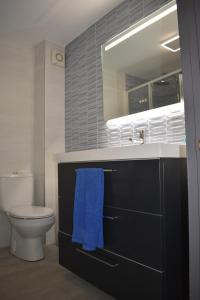 un bagno con un lavandino, un water e un asciugamano blu di Casa de Isa VV-2776-AS a Cudillero Altre 15 foto