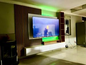 a large flat screen tv on a wall at RaHa Soul Sanctuary - Entire Home in De Deur