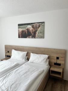 a bedroom with two beds and a picture of two cows at Gasthaus Engel in Murg