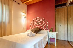 a bedroom with a bed with a flower painted on the wall at La Pérgola Habitaciones Rústicas in Es Pujols