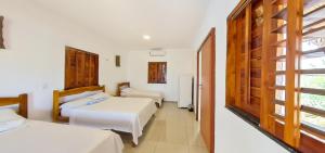 una camera d'albergo con due letti e una finestra di Amazônia Kite Club a Luis Correia
