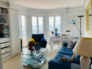 a living room with a blue couch and a table at Luxury Apartment with amazing SEA view at Cap d'Antibes in Antibes