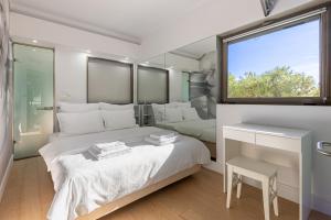 a bedroom with a large bed and a window at Cozy Riviera Apartment in Varkiza