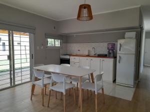 a kitchen with a table and chairs and a refrigerator at Los Robles in Mercedes