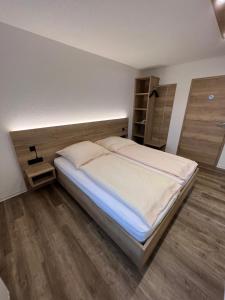 1 dormitorio con 1 cama grande y suelo de madera en Gasthaus Engel, en Murg