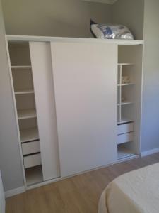 a bedroom with a white closet with shelves at Los Robles in Mercedes