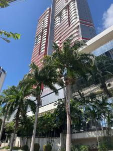 un edificio alto con palme di fronte di Studio particular em Hotel a Salvador