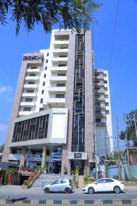 two cars parked in front of a large building at Bella Furnished Apartment 2 in Addis Ababa