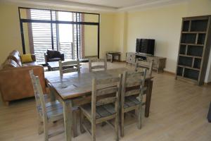 sala de estar con mesa de madera y sillas en Bella Furnished Apartment 2 en Addis Abeba