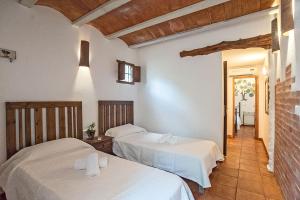 a bedroom with two beds and a hallway at La Pérgola Habitaciones Rústicas in Es Pujols