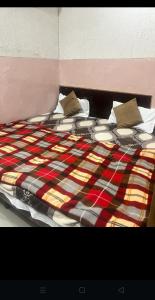 een bed met een kleurrijke deken en kussens erop bij Arora guest house in Amritsar