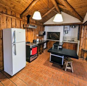 a kitchen with a white refrigerator and a stove at EL FURANCHO in San Martín de los Andes