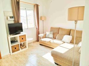 een woonkamer met een bank en een tv bij Villa Casa Max - duplex-apartment in Villamartin Golf Resort in Villamartin
