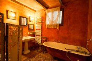 een badkamer met een bad en een wastafel bij Locanda dei Melograni in Gossolengo