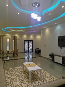 a lobby with a table in the middle of a room at منزل مريح بحديقة ومسبح خاص in Abyār ‘Alī
