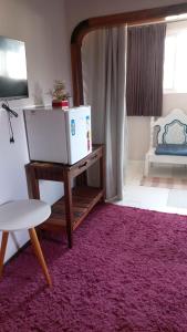 una sala de estar con una alfombra rosa y una mesa en Caminho do Sol Pousada, en Chapada dos Guimarães