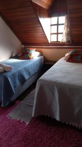 two beds in a room with a window at Caminho do Sol Pousada in Chapada dos Guimarães