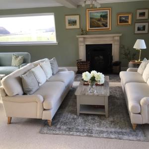 uma sala de estar com dois sofás e uma lareira em Castlecroft Bed and Breakfast em Stirling