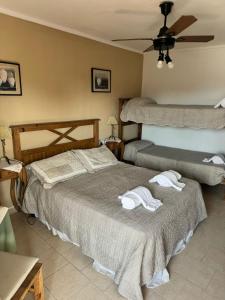 1 dormitorio con 2 camas y toallas. en Hotel Albert en Villa Gesell