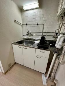 a kitchen with a sink and a counter top at 1-3サン　地下鉄徒歩圏内サービスアパ―トメントSAPPORO Shiroish iStation エアコンネット完備 in Tsukisappu