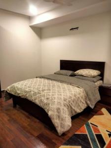 um quarto com uma cama com um edredão em Pine Heights Luxury Apartment em Islamabad