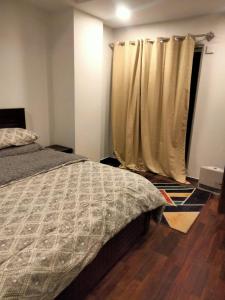 um quarto com uma cama e uma cortina em Pine Heights Luxury Apartment em Islamabad