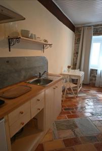 eine Küche mit Spüle und einem Tisch in der Unterkunft Sunshine ready in Piran
