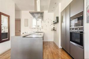 cocina con fregadero y fogones horno superior en City Life Milan Apartment - Wi-Fi & Smart TV, en Milán