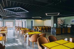 une salle à manger avec des tables et des chaises jaunes dans l'établissement D&D HOTEL, à Nilüfer