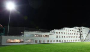 - un grand bâtiment blanc la nuit avec un éclairage de rue dans l'établissement D&D HOTEL, à Nilüfer