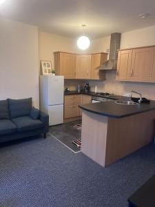 a kitchen with a couch and a refrigerator and a counter at City centre apartment in Sunderland