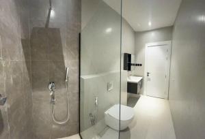W łazience znajduje się toaleta i przeszklony prysznic. w obiekcie Al Azmy Al Ared Hotel w Rijadzie